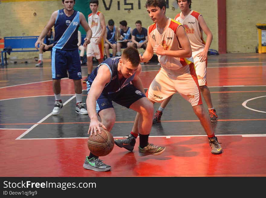 Athlete dribbling ball during basketball on indoor court. Athlete dribbling ball during basketball on indoor court.