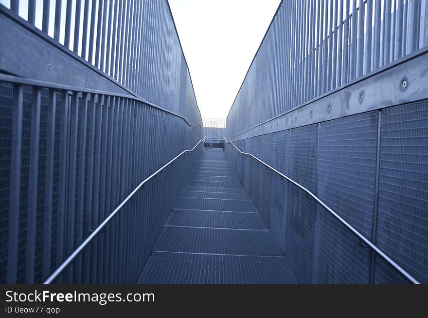 Metal walkway with mesh fencing on sunny day. Metal walkway with mesh fencing on sunny day.