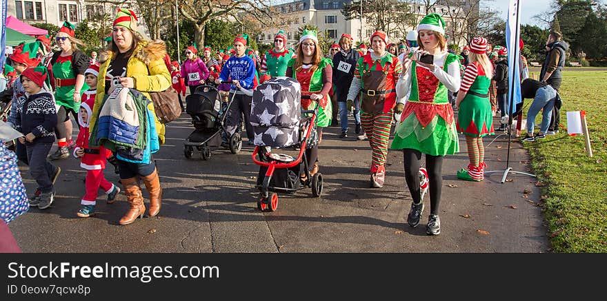 People in elf outfits on street during Christmas parade. People in elf outfits on street during Christmas parade.