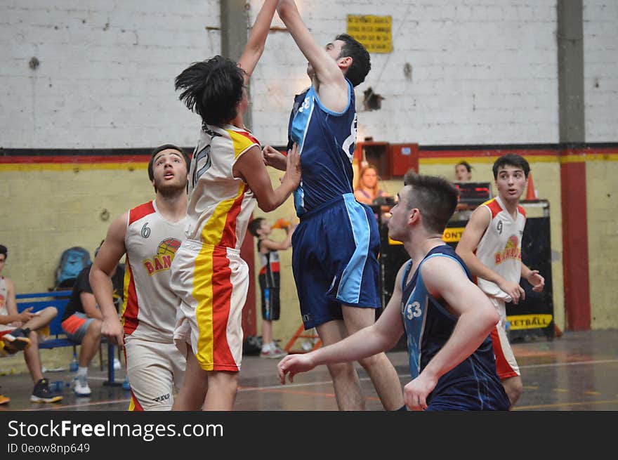 Players in jump ball during basketball game on indoor court. Players in jump ball during basketball game on indoor court.