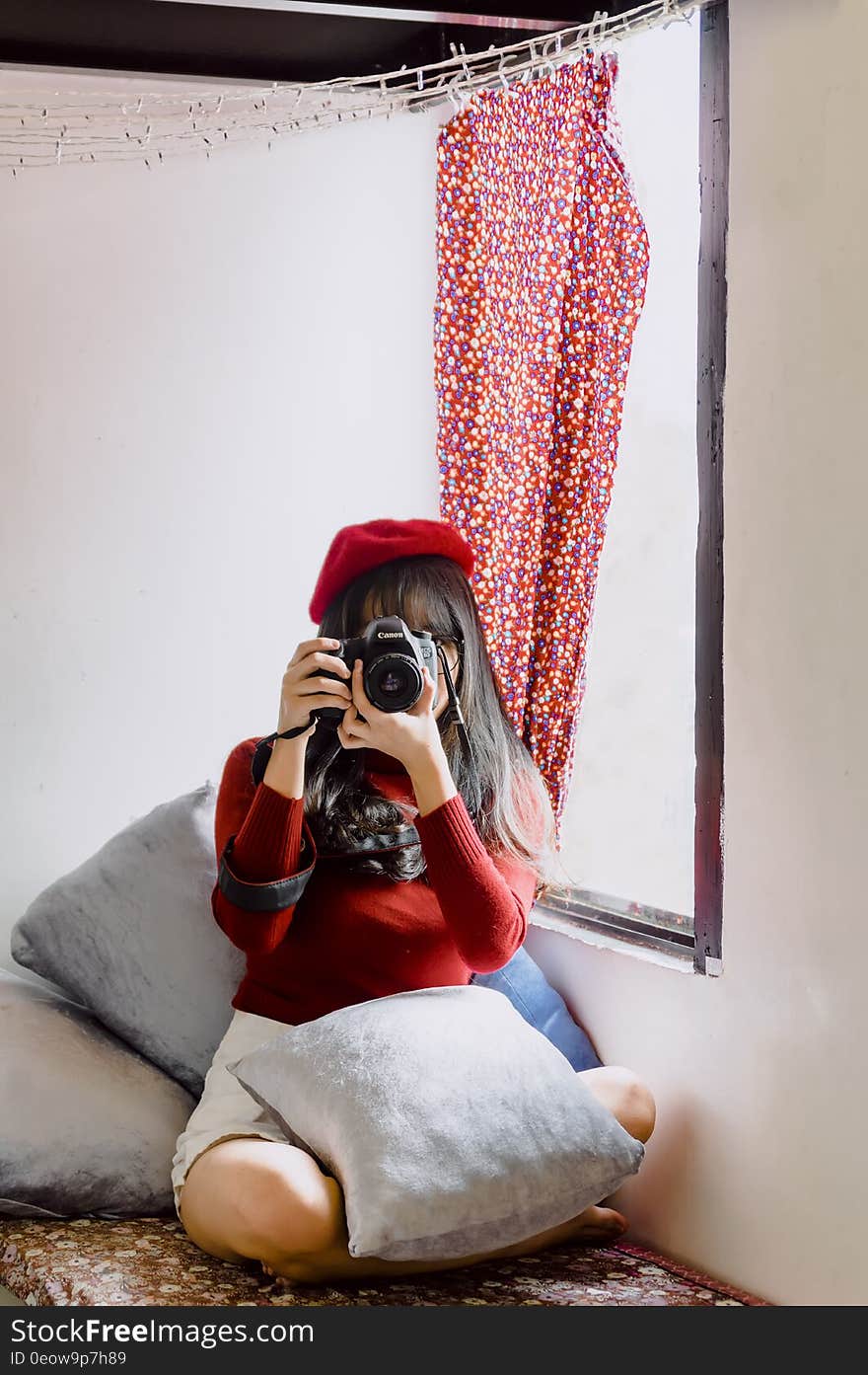 Portrait of female photographer sitting inside with camera. Portrait of female photographer sitting inside with camera.