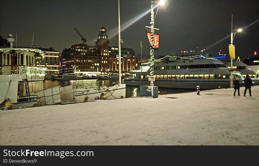 Snow covered waterfront marina illuminated at night. Snow covered waterfront marina illuminated at night.