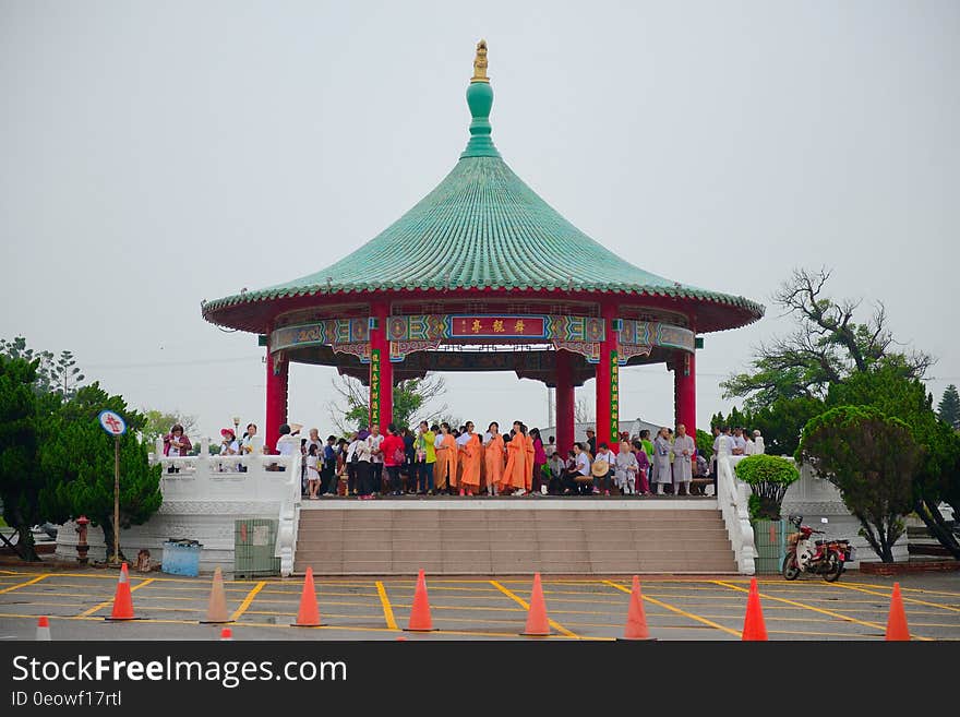 An Asian or Chinese pavilion with people under overcast skies.