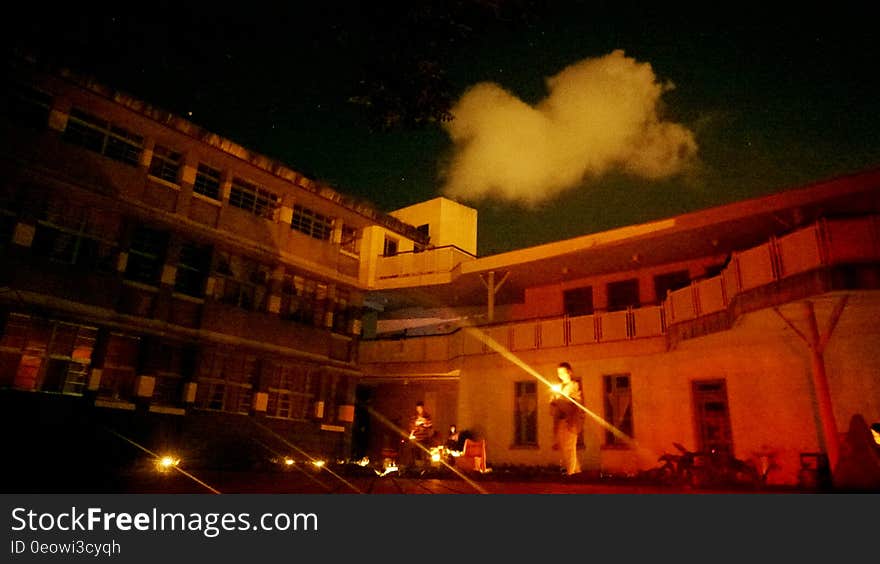 People holding flashlights standing outside industrial building at night. People holding flashlights standing outside industrial building at night.