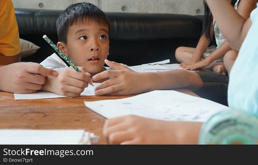 A group of children reading and writing and studying. A group of children reading and writing and studying.