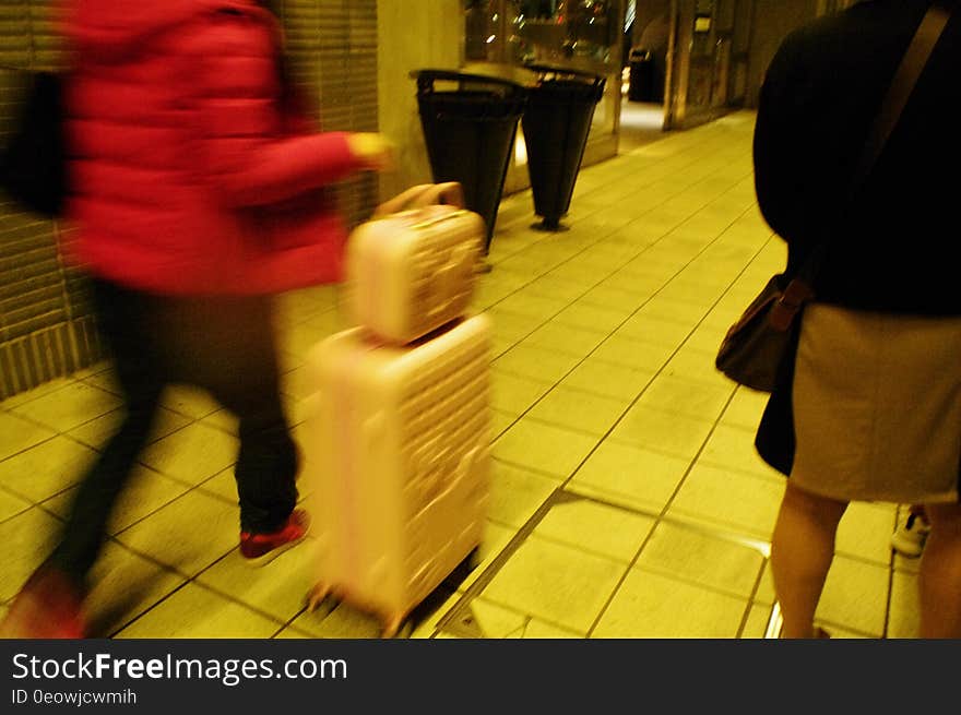 A blur of passengers walking on a street or in airport with luggage in hand. A blur of passengers walking on a street or in airport with luggage in hand.