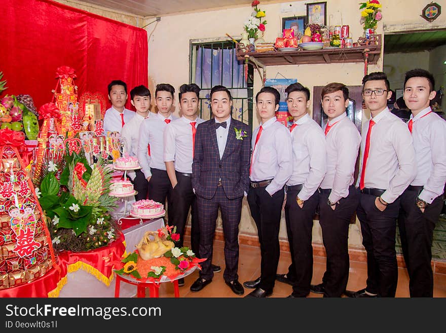 A group of Asian men standing in line next to a table. A group of Asian men standing in line next to a table.