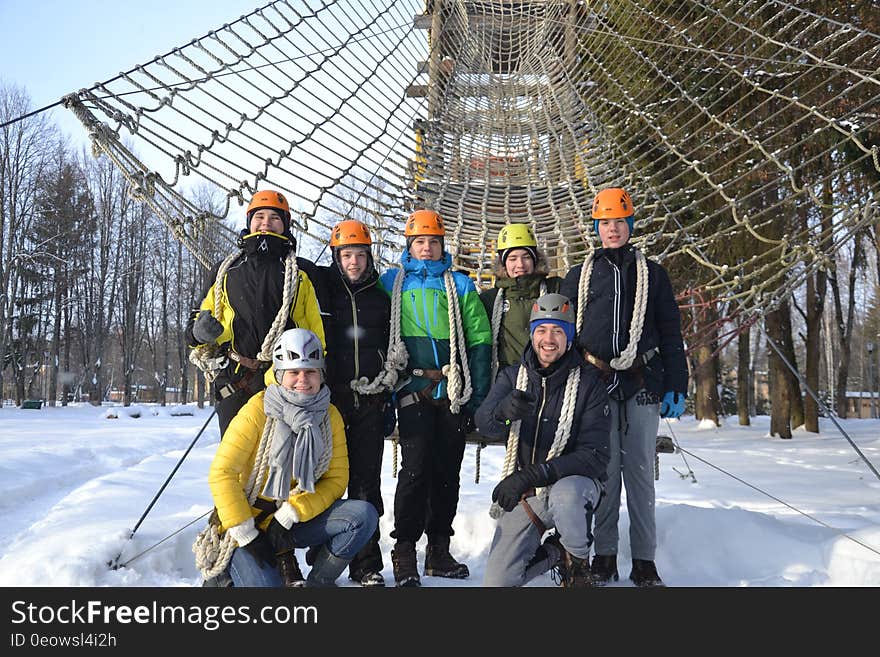 A group of people posing in front of an obstacle course in the winter. A group of people posing in front of an obstacle course in the winter.