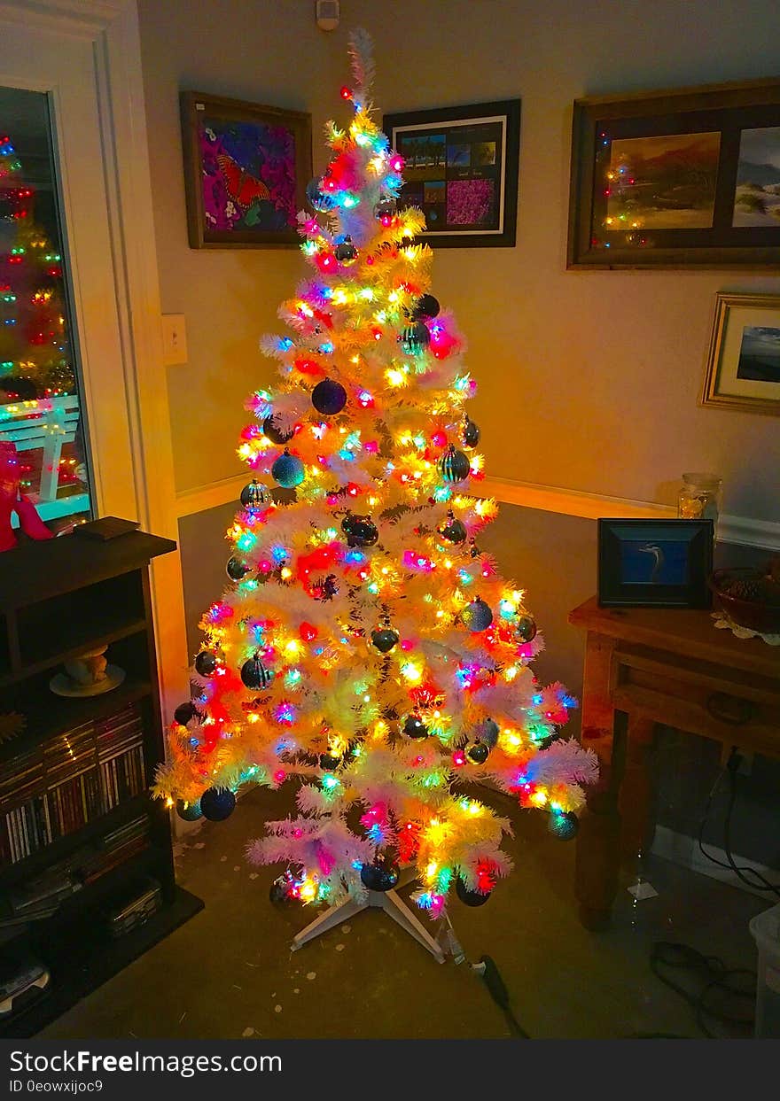 A colorful Christmas tree standing in the living room of a home.