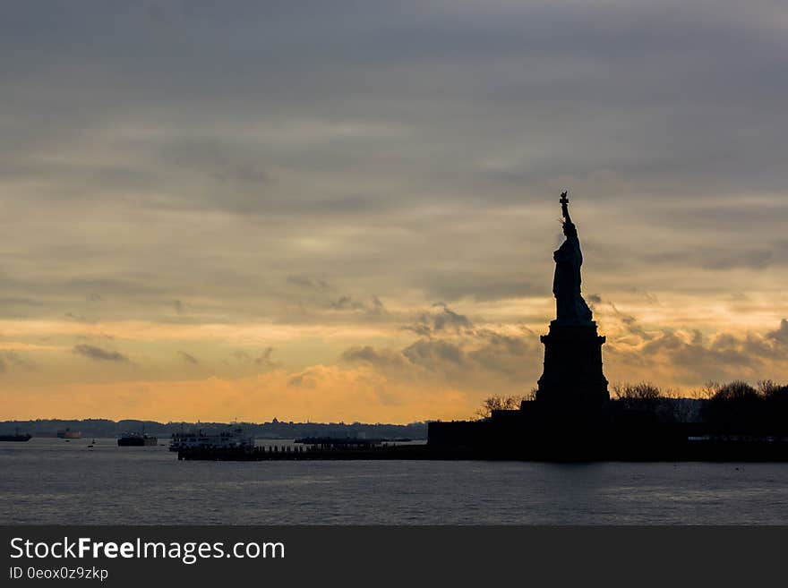 The silhouette of the Statue of Liberty by the sunset. The silhouette of the Statue of Liberty by the sunset.