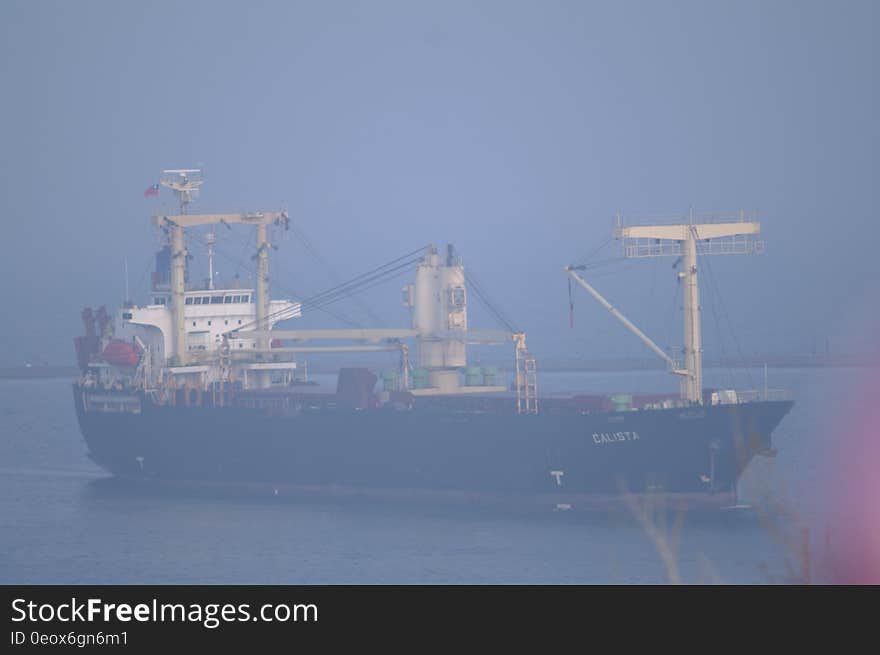 Large ship, maybe oil tanker, with dark hull and white superstructure sailing on a calm sea, gray sky. Large ship, maybe oil tanker, with dark hull and white superstructure sailing on a calm sea, gray sky.