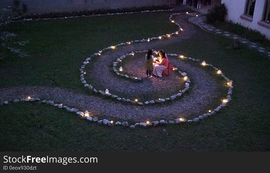 A garden with a path in spiral shape lit by lanterns and candles. A garden with a path in spiral shape lit by lanterns and candles.