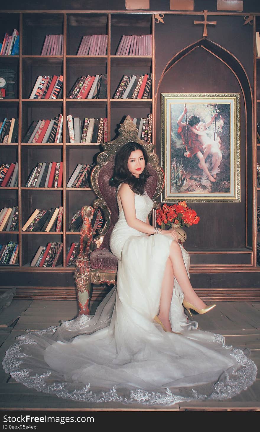 Portrait of Asian bride in white gown sitting in chair inside library. Portrait of Asian bride in white gown sitting in chair inside library.