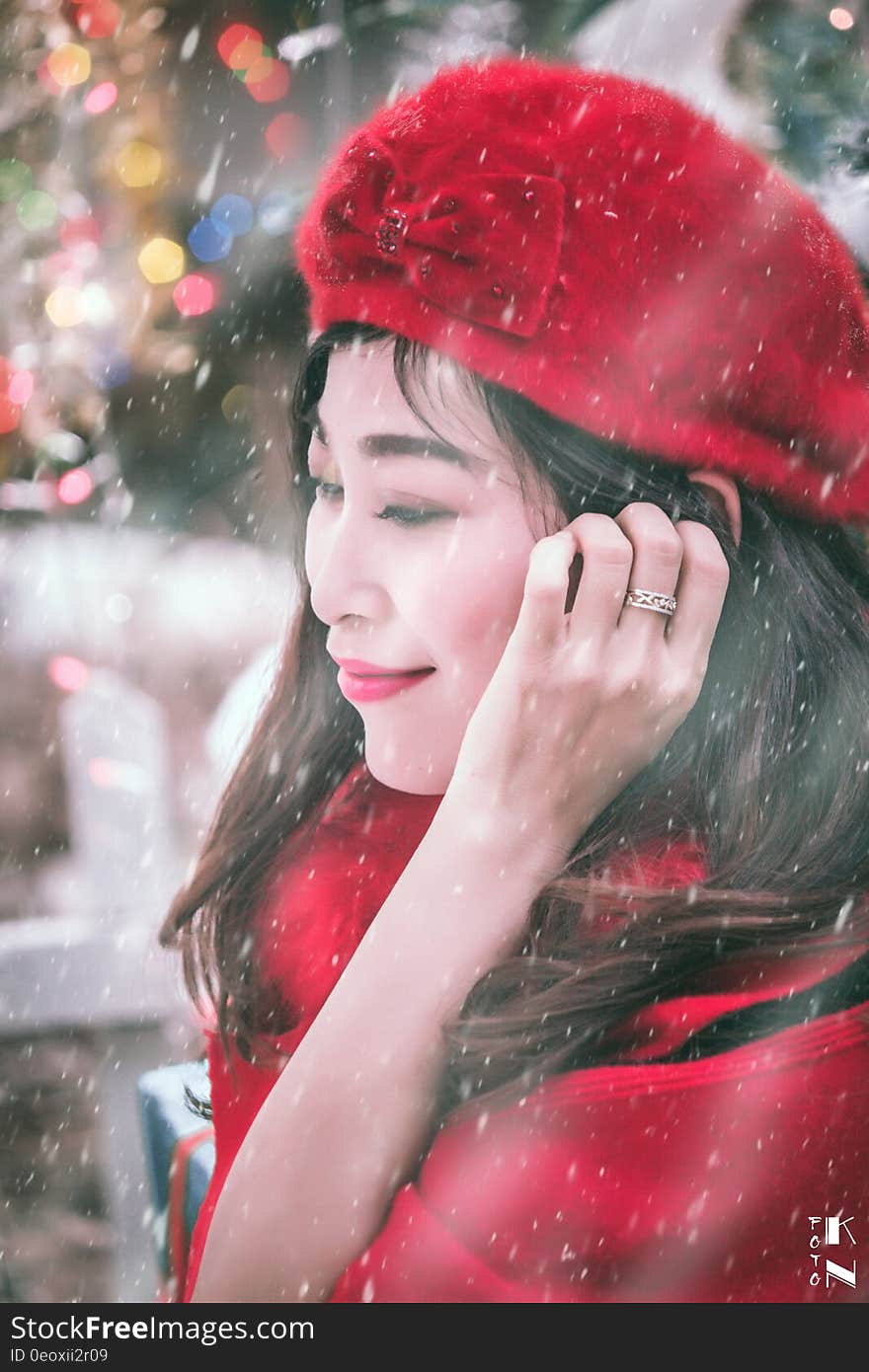 Outdoor winter portrait of Asian woman wearing red had and coat in snow storm. Outdoor winter portrait of Asian woman wearing red had and coat in snow storm.