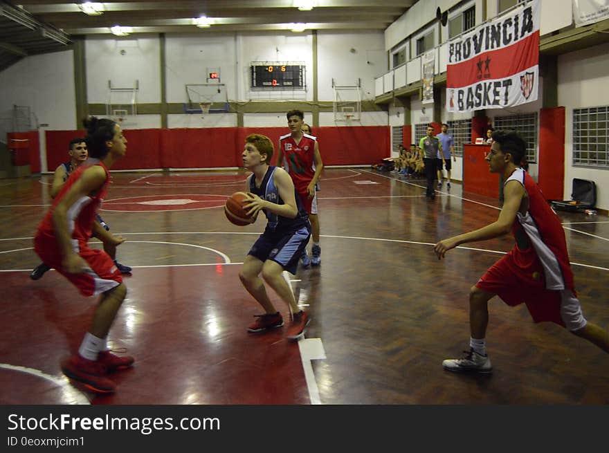 A group of men playing basketball on a court.