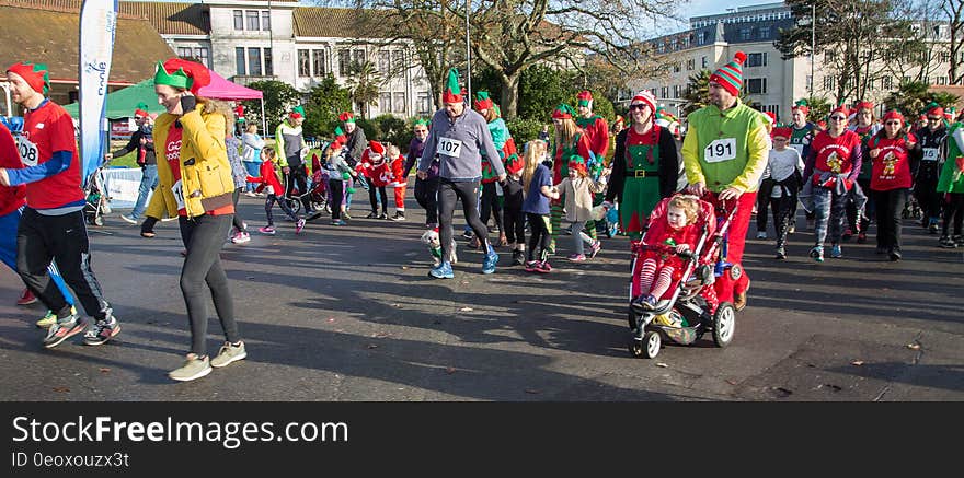 People in elf costumes in parade on city streets. People in elf costumes in parade on city streets.