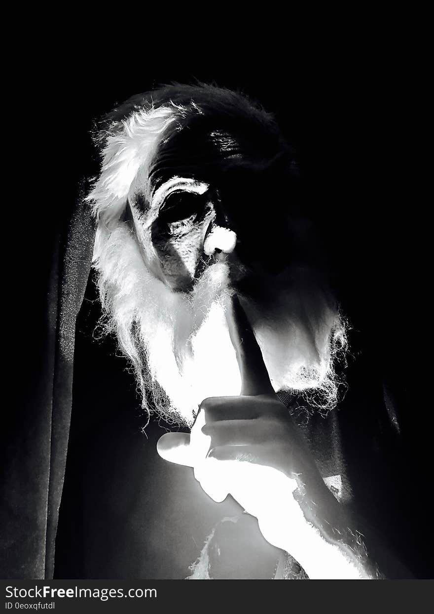 Black and white portrait of old man overexposed with dark shadows.