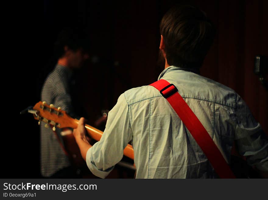 Back of man playing guitar.