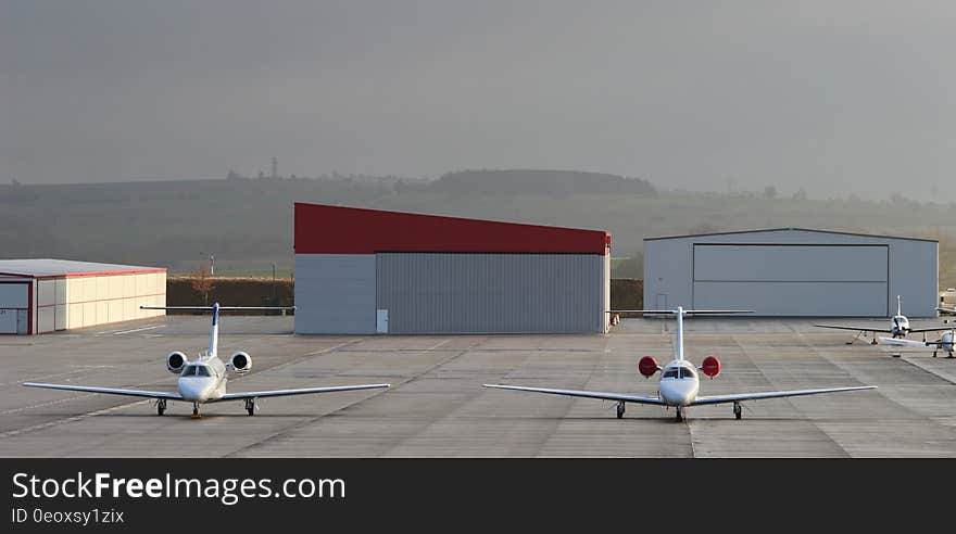 Planes on tarmac outside terminal buildings on sunny day. Planes on tarmac outside terminal buildings on sunny day.