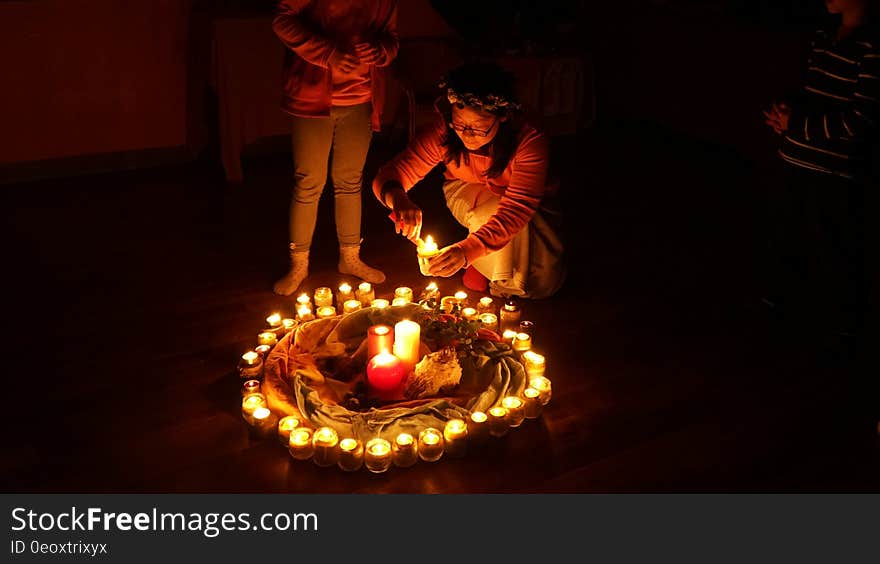 Young girl lighting candle as part of fire ring. Young girl lighting candle as part of fire ring.