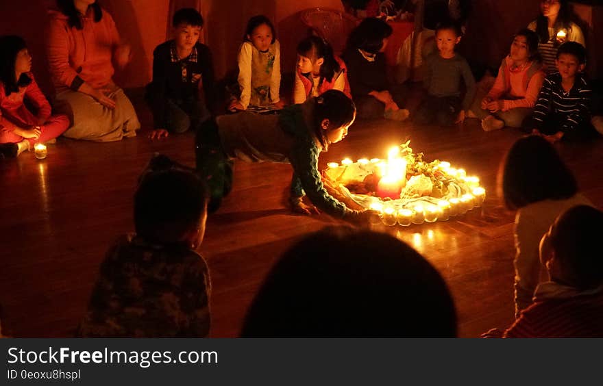 Children sitting in circle on floor around burning candles. Children sitting in circle on floor around burning candles.