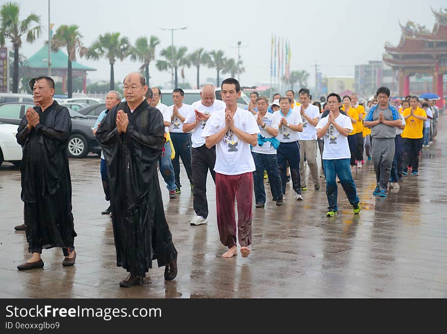 Procession of men walking with folded hands down wet streets in rain storm. Procession of men walking with folded hands down wet streets in rain storm.