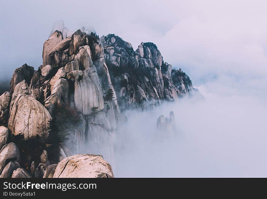 Fog covering rocky ridge along remote hillside. Fog covering rocky ridge along remote hillside.