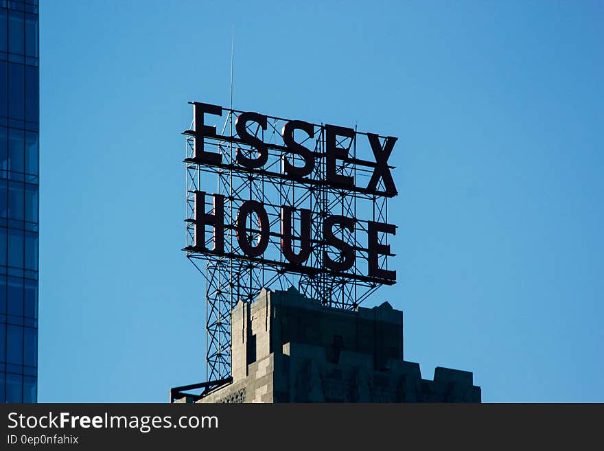 Essex House sign on modern rooftop against blue skies. Essex House sign on modern rooftop against blue skies.