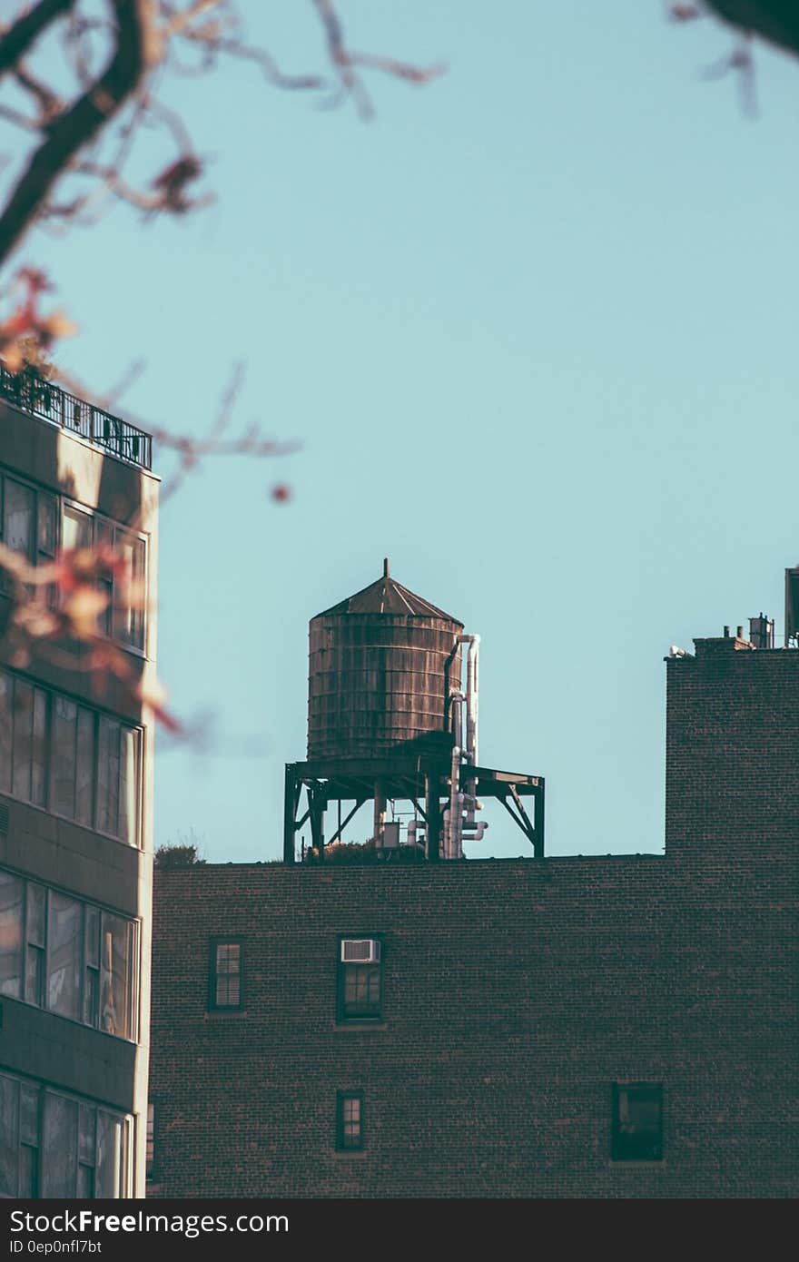 Water tower on modern rooftop in city against blue skies. Water tower on modern rooftop in city against blue skies.