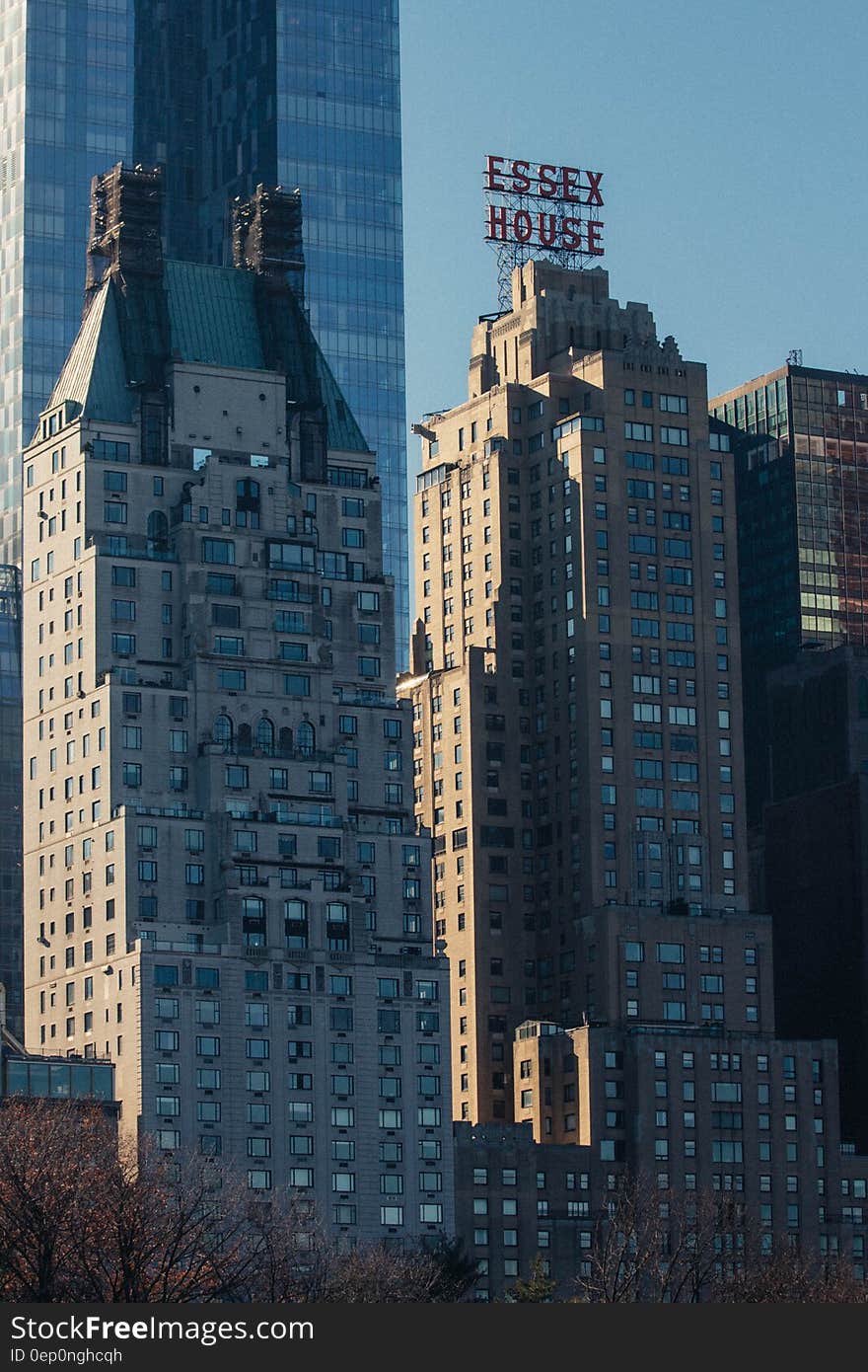 Essex House sign on rooftop of building in modern city skyline.