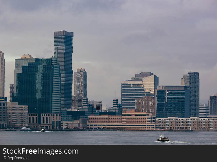 Panoramic view of modern city skyline viewed across river or coastline.