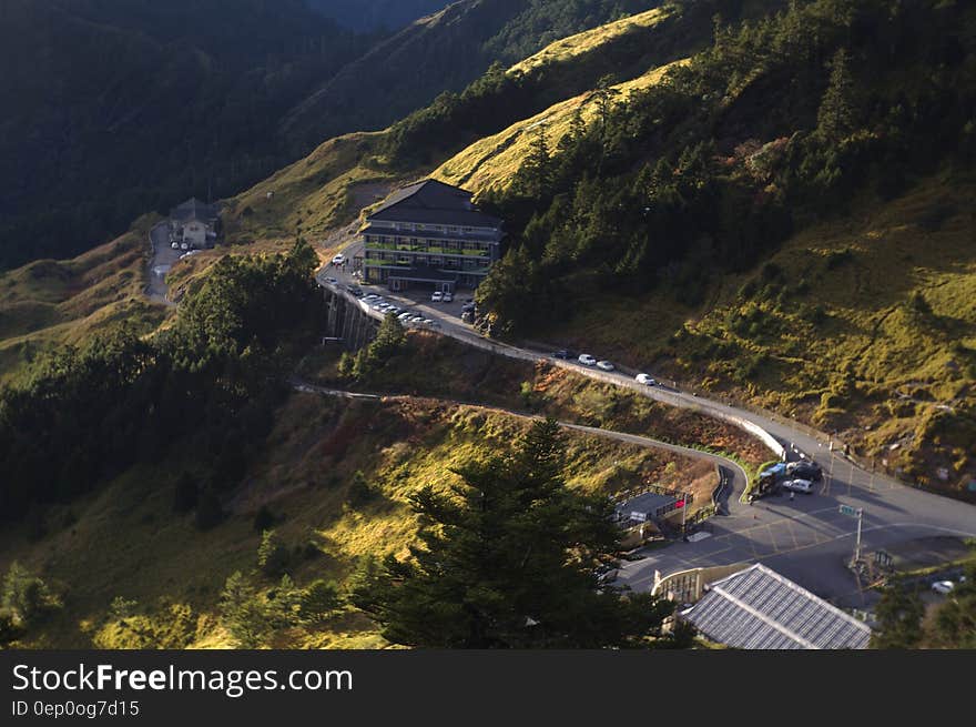 Aerial view of winding road on mountainside leading to car park.