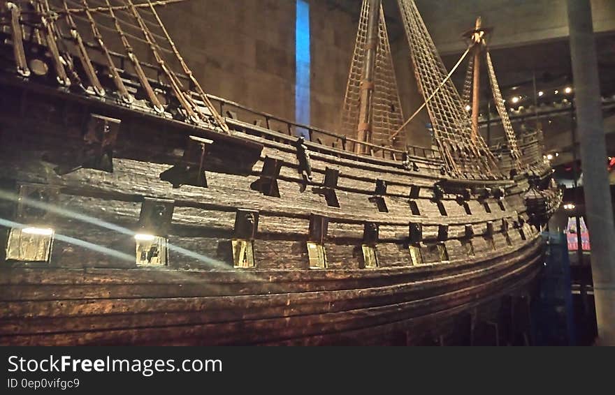 Hull and deck of vintage wooden sailing ship with masts inside museum hall. Hull and deck of vintage wooden sailing ship with masts inside museum hall.