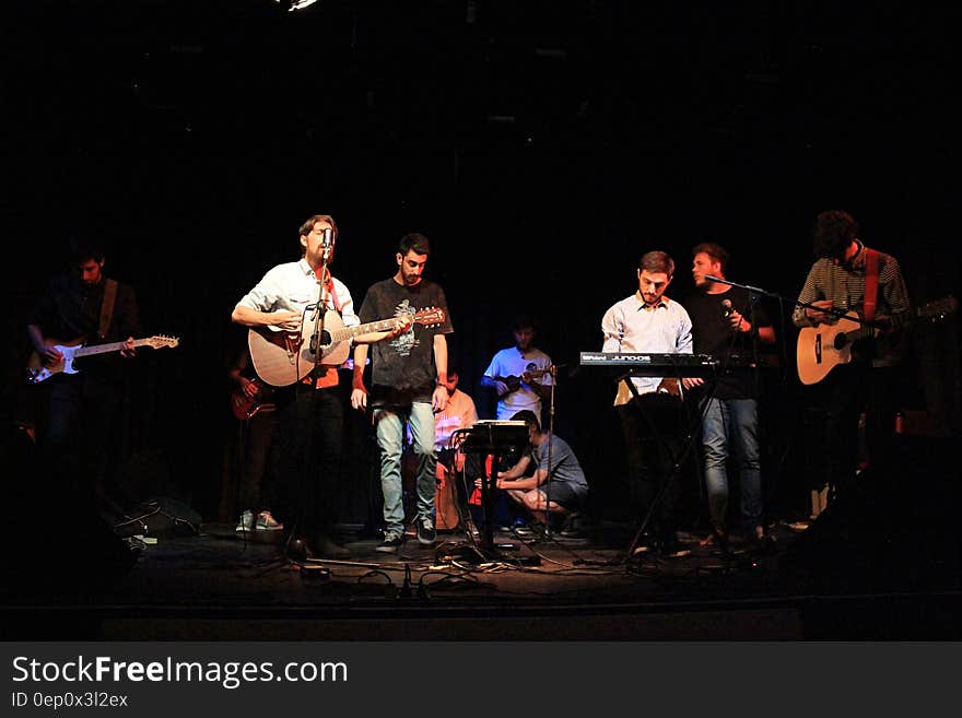 Band of musicians onstage playing instruments and singing.