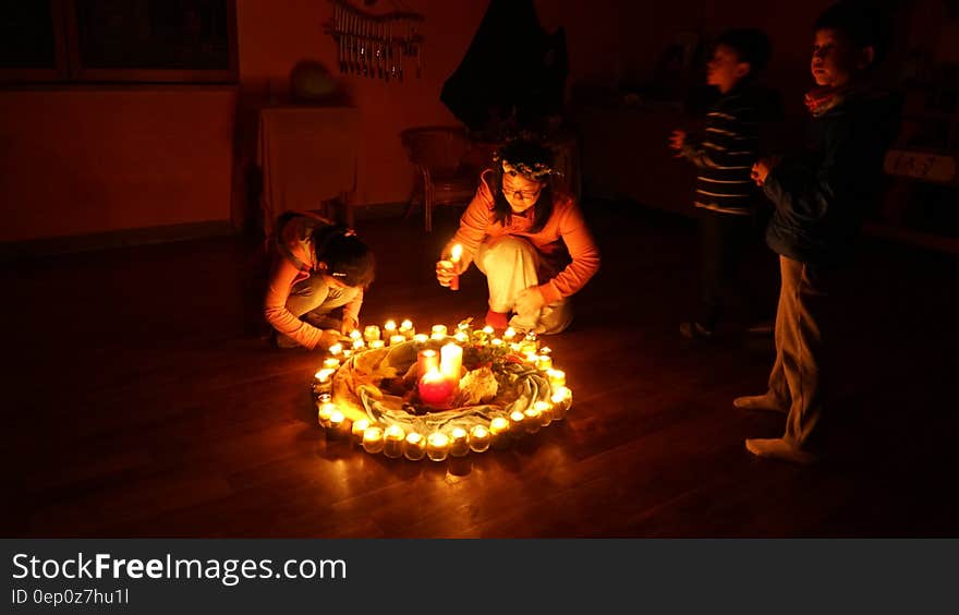 Children lighting candles in a circle on floor inside room. Children lighting candles in a circle on floor inside room.