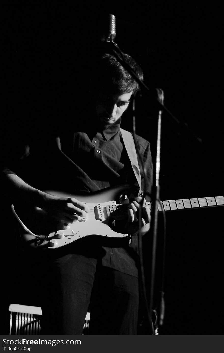 Musician onstage playing electric guitar in black and white. Musician onstage playing electric guitar in black and white.