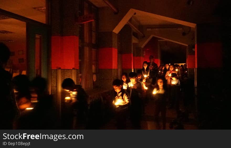 Children holding lit candles in indoor ceremony. Children holding lit candles in indoor ceremony.