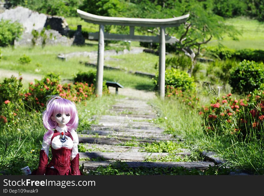 Doll along path through garden with gazebo on sunny day. Doll along path through garden with gazebo on sunny day.