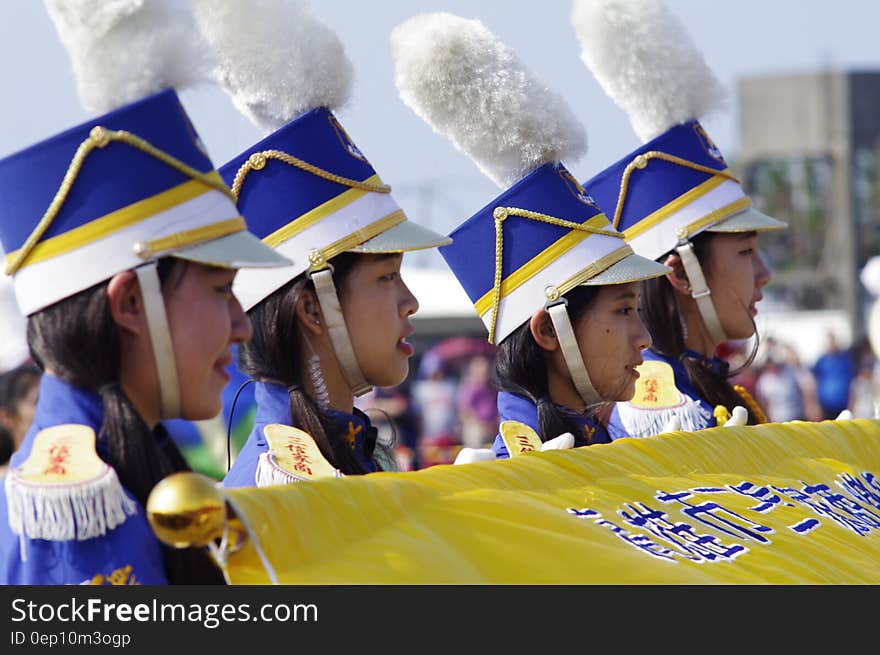 Asian teenage girls in marching band uniforms holding yellow banner. Asian teenage girls in marching band uniforms holding yellow banner.