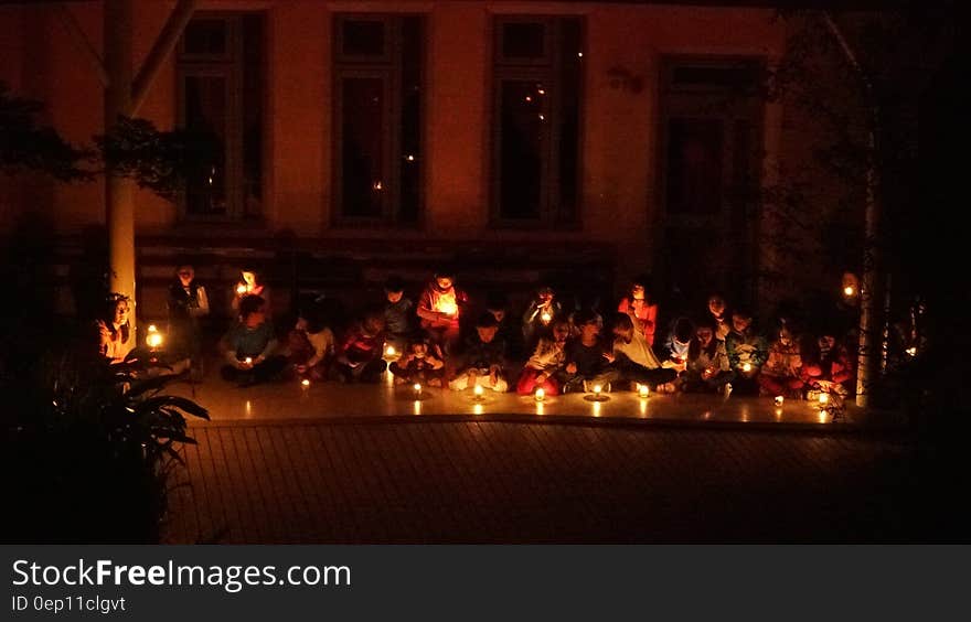 Schoolchildren sitting on floor in candlelight ceremony. Schoolchildren sitting on floor in candlelight ceremony.