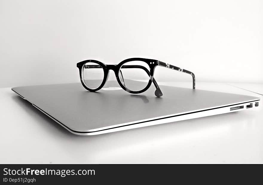 Black Frame Eyeglasses on Silver Macbook Air