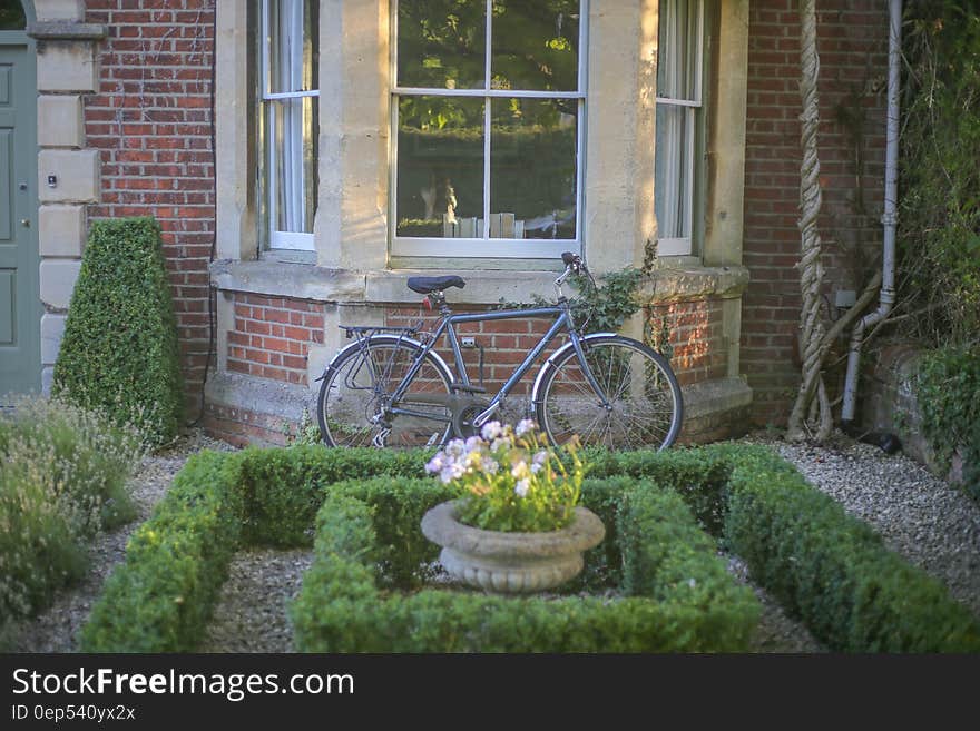 Grey Mountain Bike Leaning on Brown Wall Brick in Garden