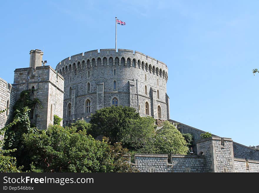 Gray Concrete Castle With Flag on Top Under Blue Sky