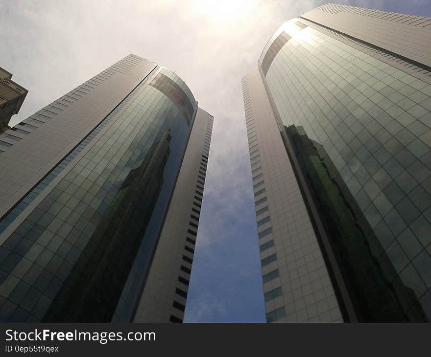 Upward angle on skyscrapers against white clouds and blue skies on sunny day. Upward angle on skyscrapers against white clouds and blue skies on sunny day.