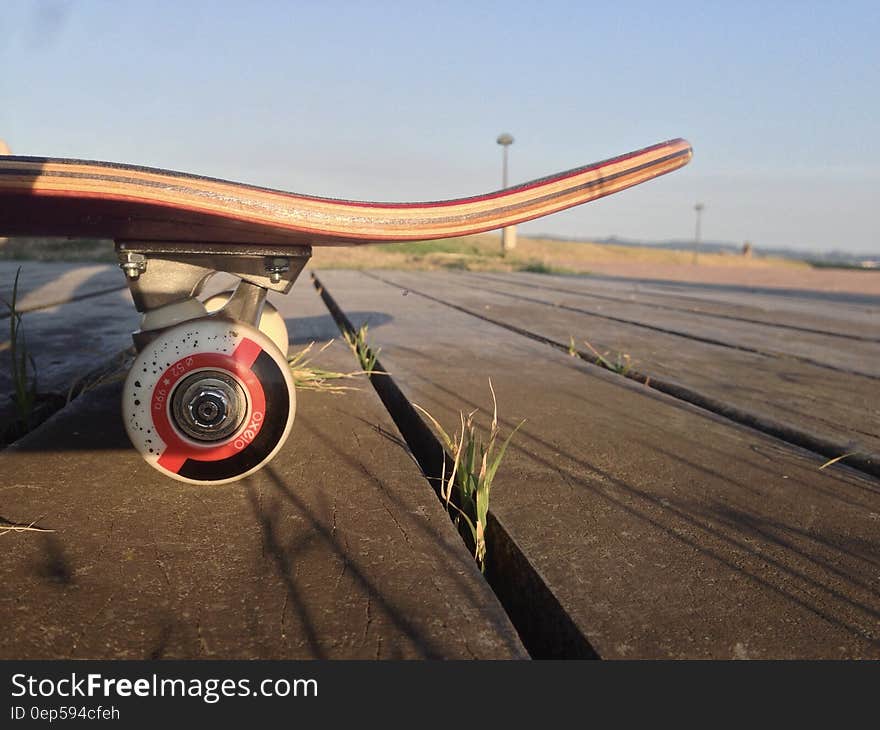 Red and Brown Skateboard on Gray Road