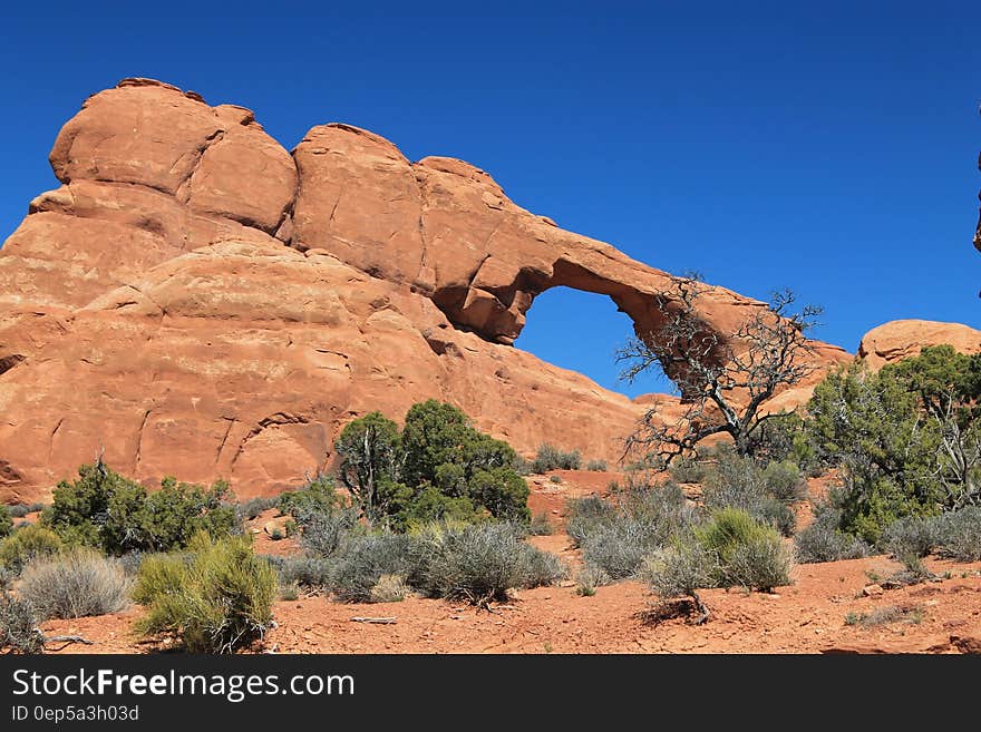 Arc Rock Formation Under Blue Clouds during Daytime