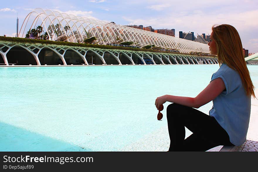 Woman Wearing Blue Shirt in Front of Green Lake