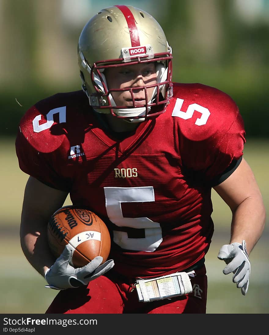 Man in Red and White Roos 5 Football Jersey Playing Football