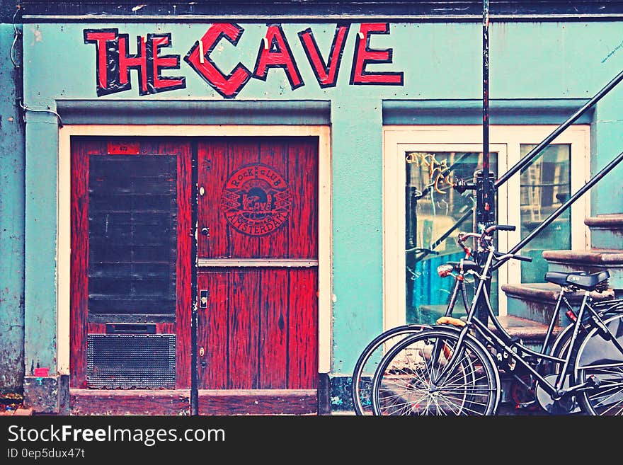 Black Beach Cruiser Bike Beside the Red Wooden Door Outside