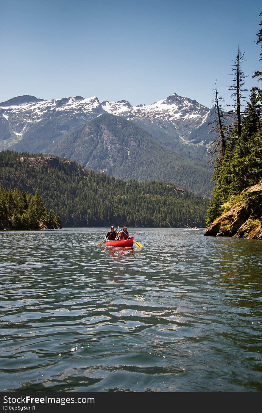 Couple canoeing on lake alpine valley. Couple canoeing on lake alpine valley.